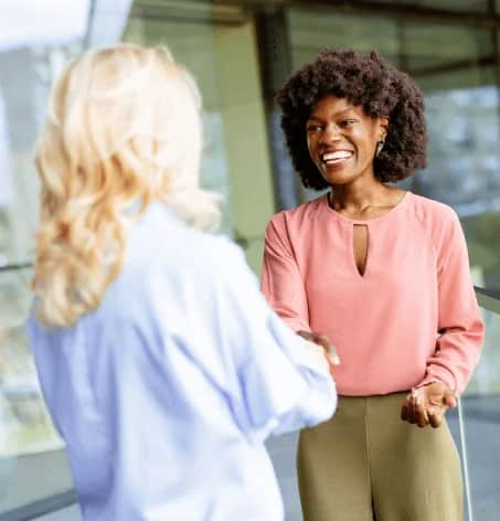 Women shaking hands smiling